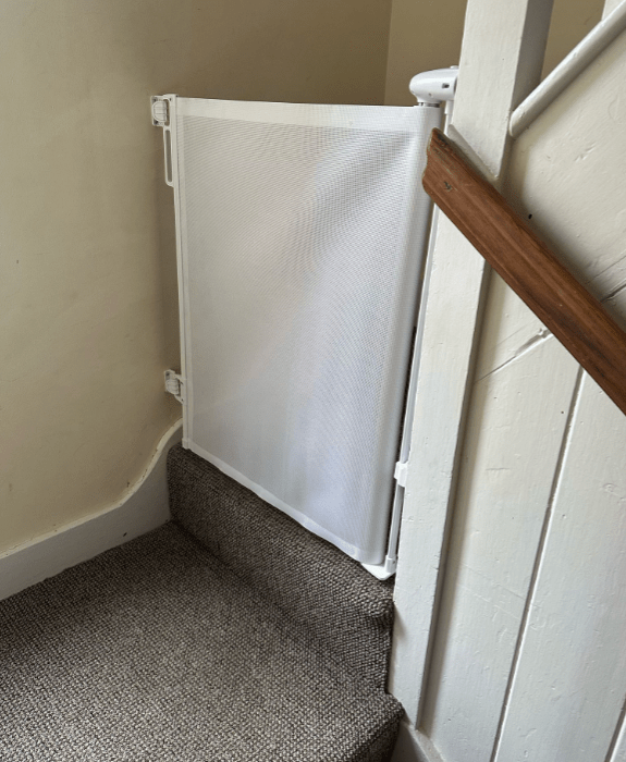 Retractable stair gate to keep dogs safely downstairs